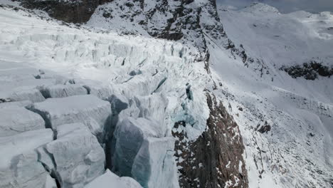 Drohnenansicht-Eines-Großen-Gletschers,-Der-Sich-An-Einem-Sonnigen-Tag-Im-Winter-In-Den-Alpen-Widerspiegelt
