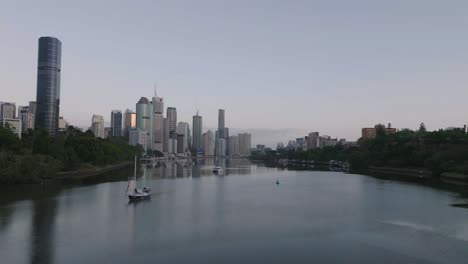 Drone-Cinematográfico-Volando-Bajo-Sobre-El-Río-Hacia-La-Ciudad-De-Brisbane-Al-Amanecer