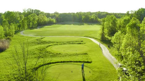 Luftvideo-Eines-Wunderschönen-Golfplatzes-Mit-Einem-Golfer,-Der-Einen-Ball-Mit-Einem-Driver-Vom-Abschlag-Schlägt