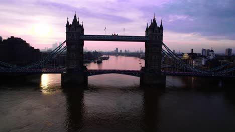 Incredible-4K-footage-of-a-drone-passing-through-tower-bridge-in-thames-river-at-sunset,-London