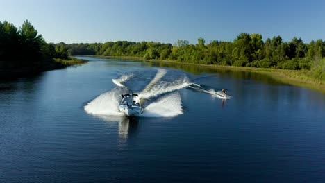 Drone-video-of-a-wakeboarder-behind-a-boat-on-a-lake