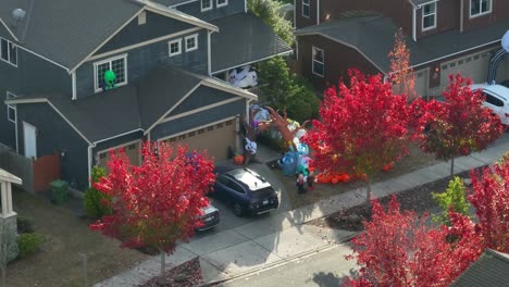A-suburban-American-home-with-a-yard-full-of-inflatables-surrounded-by-red-leaves-in-the-trees