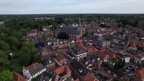 Picturesque-aerial-view-of-historic-Dutch-city-Groenlo-with-church-tower-rising-above-the-authentic-medieval-rooftops-on-an-overcast-day
