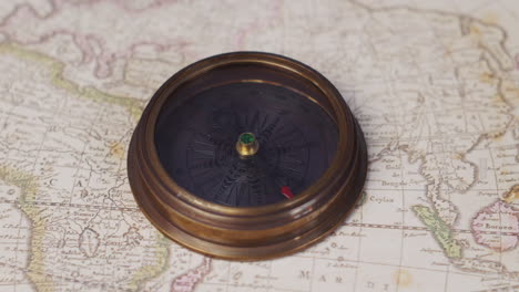 A-nautical-compass-lying-on-a-vintage-map-of-the-world