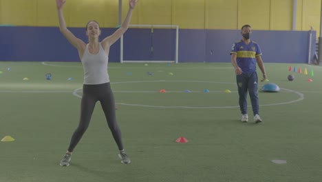 woman-training-on-soccer-field-doing-jumping-with-the-trainer