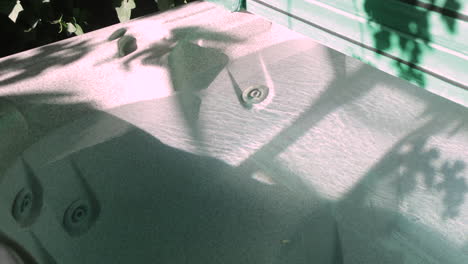 4K-capture-of-an-above-ground-jacuzzi,-with-vine-shadows