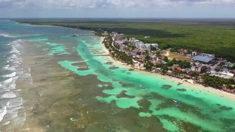 Cinematic-drone-shot-of-the-coastal-resort-town-of-Mahahual-Mexico-with-waves-breaking-on-reef