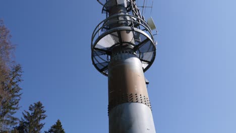 Tilt-up-to-a-high-transmission-mast-standing-in-a-rural-field-in-Switzerland