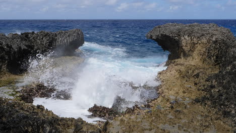 Powerful-waves-crashing-against-rocks-on-Pacific-coastline,-slow-motion