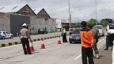 Security-officers-from-the-Indonesian-National-Police-and-Armed-Forces-intercept-vehicles-leaving-the-Toll-Road,-to-be-checked-for-transmission-of-Covid-19,-Pekalongan,-June-17,-2021