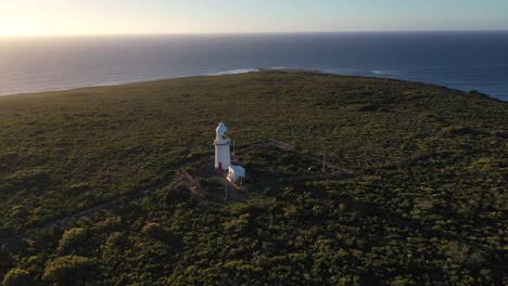 Drone-Aerial-of-Cape-Naturaliste-Lighthouse,-Historic-Landmark-With-Magical-View-on-Indian-Ocean-at-Golden-Hour-Sunlight