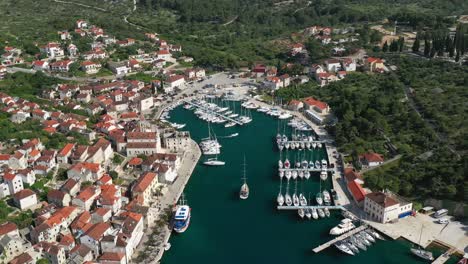 Luftaufnahme-Von-Yachten-Und-Booten-Auf-Steg-Mit-Dorf-Milna-Auf-Der-Insel-Brac-In-Kroatien