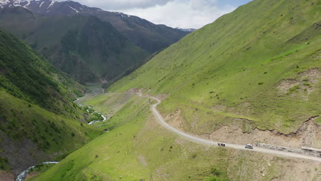 Rotating-drone-shot-of-a-road-in-the-Caucasus-mountains-leading-to-Juta-Georgia