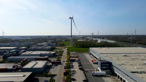 Flying-towards-spinning-windmill-at-the-edge-of-industrial-zone