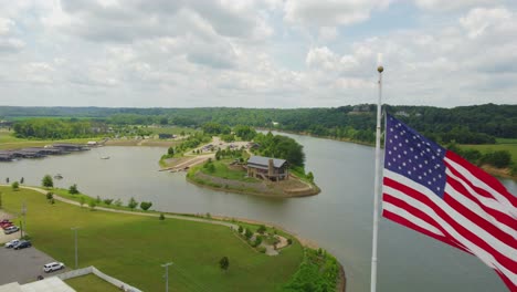 Flying-past-an-American-Flag,-heading-toward-Clarksville-Marina-in-Clarksville,-Tennessee