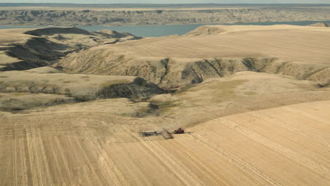 Seeding-on-farm-land-in-Canada-at-Lake-Diefenbaker,-aerial-drone-shot