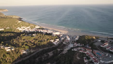 Pull-back-aerial-over-resorts-overseeing-Salema-beach-in-the-portuguese-region-of-Algarve