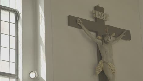 Kamerafahrten-Zu-Einem-Kruzifix-In-Einer-Kirche,-Kronleuchter-Im-Vordergrund