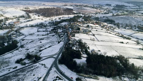 North-York-Moors-Snow-Scene-Drone-Flight,-Castleton,-Westerdale,-Rosedale,-Flight-over-Castleton,-reveal-pan-upwards,-Winter-cold-and-moody-clouds,-Phantom-4,-Clip-7