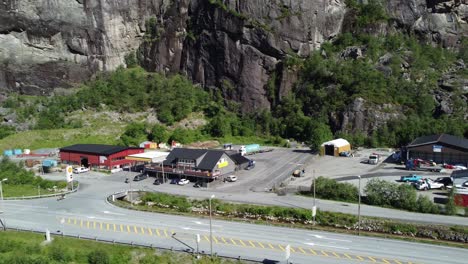 Truck-stop-with-cafe-and-Shell-gasoline-station-beside-Norway-highway-E16---Aerial-of-industrial-are-Dalegarden-outside-Bergen-with-passing-cars