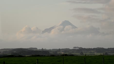 Mount-Taranaki-summit-visible-after-a-rainstorm-with-rural-farmland-in-foreground