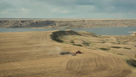 Szenische-Ansicht-Des-Landwirtschaftstraktors,-Der-Samen-Sät-Und-Feld-In-Saskatchewan,-Kanada-Kultiviert