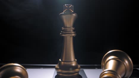 Gold-king-on-chess-board-last-survivor,-dramatic-twirling-smoke-behind