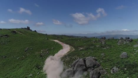 rally-car-going-up-a-mountain-,shot-by-drone