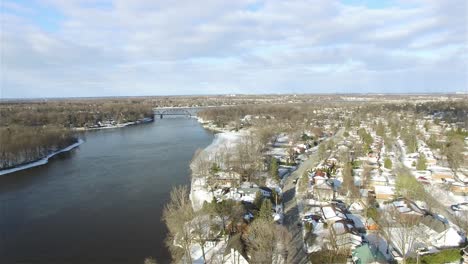 Aerial-view-of-a-neighborhood-in-the-winter-surrounded-by-water-on-a-sunny-day
