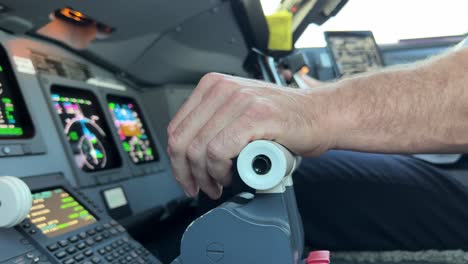 Close-view-inside-a-jet-cockpit-while-copilot-is-handling-thrust-levers-and-control-wheel