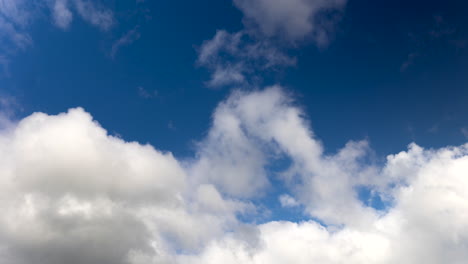 Flauschige-Weiße-Wolken,-Die-Sich-Gegen-Den-Tiefblauen-Himmel-Bewegen