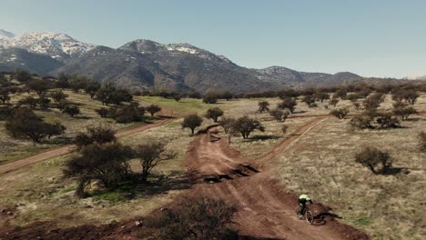 Tracking-shot-of-a-moutain-biker-in-a-bike-park,-uhd-4k-aerial