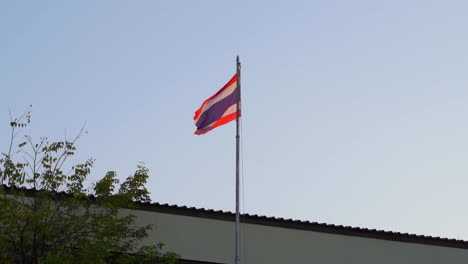 Die-Thailändische-Flagge-Weht-In-Zeitlupe-Auf-Dem-Dach-Gegen-Den-Blauen-Himmel