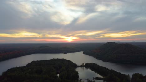Überwucherte-Landschaft-Und-Majestätischer-See-Bei-Goldenem-Sonnenuntergang,-Luftbild