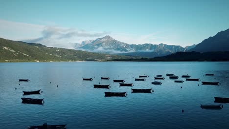Lago-De-Santa-Croce-Con-Vista-A-Las-Montañas-Dolomitas-Y-Docenas-De-Botes-De-Madera