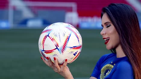 Beautiful-Brazil-fan-plays-with-football-in-stadium,-close-up