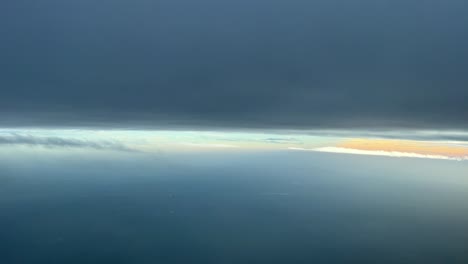 Aerial-view-from-a-jet-cockpit-while-flying-between-layers-of-clouds-in-a-cold-winter-afternoon