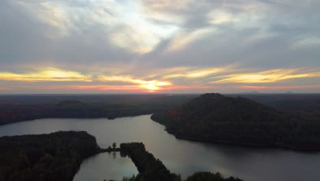 Goldener-Sonnenuntergangshimmel-über-Endloser-Waldlandschaft-Und-Bergen,-Luftbild
