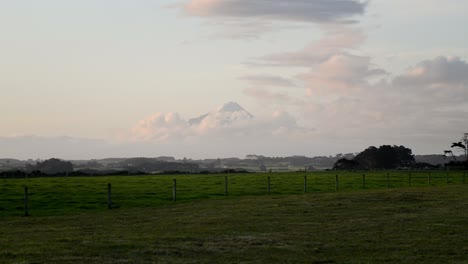 Snow-capped-peak-of-Mount-Taranaki-visible-after-a-rainstorm-during-a-vibrant-sunset