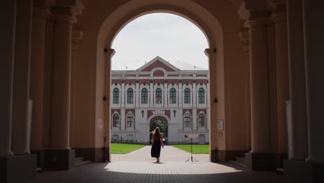 Jelgava-Palace---Woman-Tourist-Walking-Through-Arched-Gateway-to-the-Courtyard