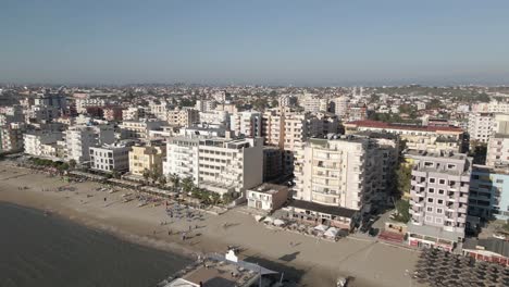 Restaurant-pier-flyover:-Quiet-sandy-beach-in-coastal-Durres,-Albania