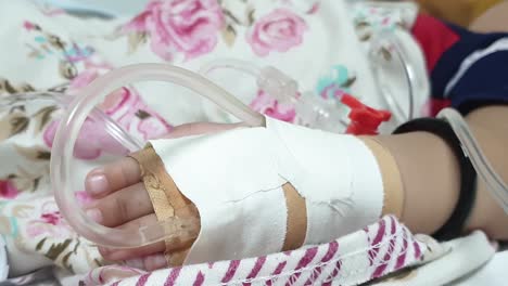 Close-Up-Shot-Of-IV-Infusion-ON-Bandaged-Hand-Laying-On-Bed
