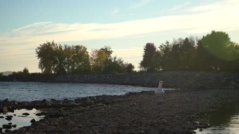 Lake-Ontario-with-low-water-level,-exposed-rocks-and-buoy-on-dry-land,-Toronto