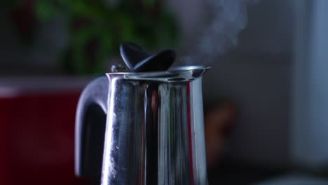 Close-up-of-a-shiny-and-reflecting-coffe-machine-that-is-brewing-coffe,-steam-rising-up