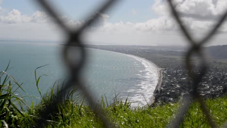 Spectacular-ocean-view-behind-blurry-chain-link-fence-in-foreground