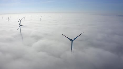 Idyllic-View-Of-Wind-Turbines-Over-Misty-Clouds-During-Daylight