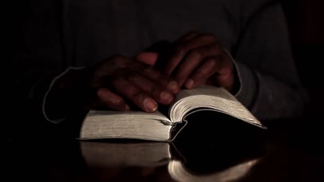 Rezando-A-Dios-Con-Las-Manos-Junto-Con-La-Biblia-Y-El-Hombre-Cruzado-Del-Caribe-Rezando-Con-Fondo-Negro-Almacen-De-Video