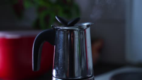 Close-up-of-a-shiny-and-reflecting-coffe-machine-that-is-brewing-coffe,-steam-rising-up