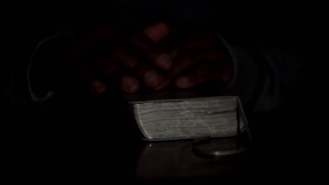 Beten-Zu-Gott-Mit-Den-Händen-Zusammen-Mit-Bibel-Und-Kreuz-Schwarzer-Mann-Beten-Mit-Schwarzem-Hintergrund-Archivvideomaterial