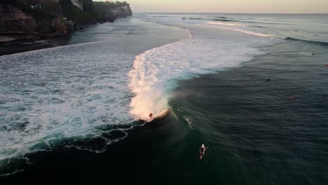 Vista-Aérea-De-Un-Surfista-Profesional-Aislado-Atrapando-Grandes-Olas-En-Uluwatu,-Isla-De-Bali,-Indonesia
